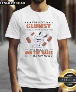 Alt Text: Funny Snoopy t-shirt design: 'I'm Not Clumsy, The Floor Just Hates Me' featuring Snoopy, table, and chairs.