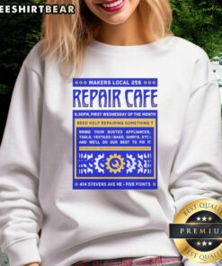 Nice Repair Cafe Makers Local 256 sweatshirt displayed on a wooden table, promoting sustainable repair culture.