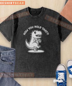 Person holding a washed T-shirt featuring a vibrant T-Rex dinosaur design, perfect for dino enthusiasts.