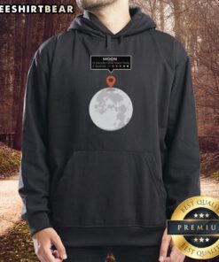 Person wearing an 'Awesome Moon Location Review' funny hoodie while standing under a starry night sky.