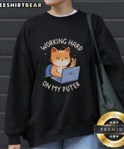 Person wearing a 'Good Working Hard On My Puter' sweatshirt while typing on a laptop at a cozy desk setup.