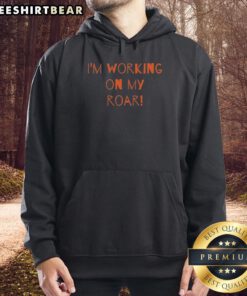 Person wearing a Top I'm Working On My Roar hoodie, showcasing a stylish design perfect for casual wear.
