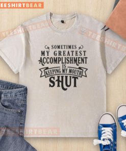 Hot 'Sometimes My Greatest Accomplishment Is Keeping My Mouth Shut' washed t-shirt displayed on a wooden table.