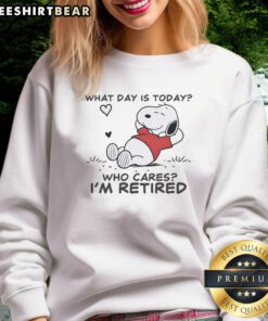 Alt Text: Official Snoopy Sleeping What Day Is Today? Who Cares? I'm Retired sweatshirt featuring a cozy design and playful graphics.