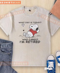 Alt Text: Official Snoopy sleeping on a 'What Day Is Today? Who Cares? I'm Retired' washed t-shirt design.