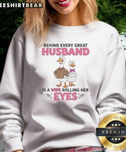Awesome Behind Every Great Husband Is A Wife Rolling Her Eyes Duck Sweatshirt displayed on a hanger.
