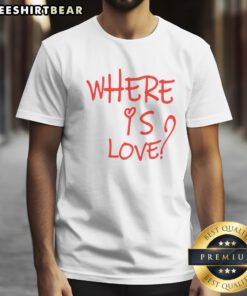 Pretty Where Is Love Red Text Shirt displayed on a wooden background, showcasing its vibrant color and unique design.